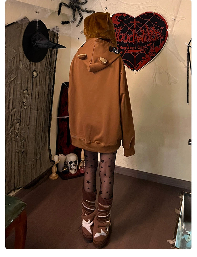 Adorned in a Seakoff Freddy-Inspired Hoodie, star-patterned tights, and cozy socks, a person stands amidst Halloween decorations, including a heart-shaped "Blood Witch" sign, witch hat, spiderwebs, and skull—perfect for horror game and Five Nights at Freddy&