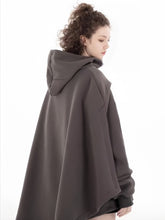 A person with long curly hair wears a Limited Edition Attack on Titan Hooded Cape – Street Style. Against a plain white background, the thick and comfortable cape subtly enhances their attire as they look to the side.