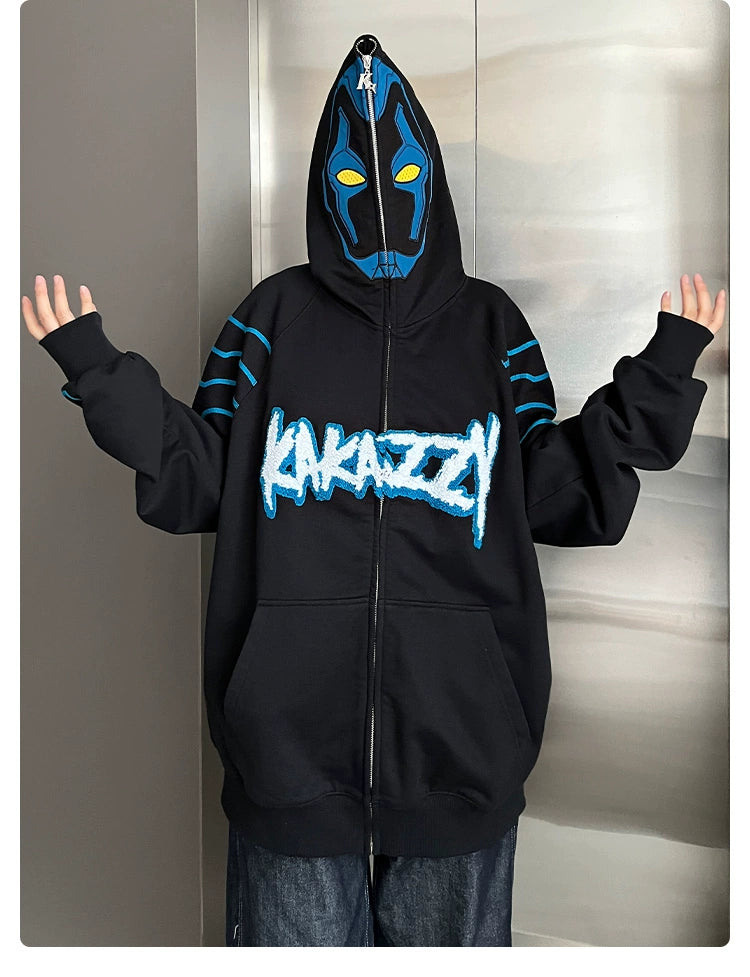 A person in a Seakoff Cyberpunk Superhero-Inspired Hoodie with blue accents and an abstract mask design raises their arms. "KANAZZY" is emblazoned in stylized blue and white letters, making it essential for fans of futuristic styles.