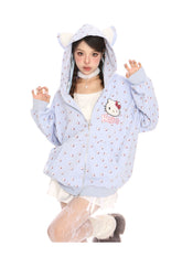 A person strikes a playful pose in a Hello Kitty Pink Kawaii Hoodie by Seakoff, featuring cat ears and an all-over print. They pair it with white lace stockings, fluffy shoes, and a choker, capturing kawaii fashion against a crisp white background.