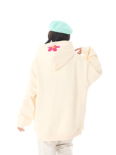 A person sports a Seakoff Kawaii Hello Kitty Oversized Hoodie, a cute pastel anime pullover perfect for Sanrio fans. Paired with a light blue hat and set against a white backdrop, their style highlights playful flair.