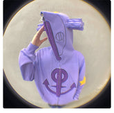 A person in a Seakoff Purple Symbol Hoodie, an oversized 400GSM Anime Zip-Up Sweatshirt, flaunts star and ear designs with arrows and circles. Their face is obscured by the zipped hood. Yellow accents on the sleeves enhance its street-chic vibe against a blurred backdrop.