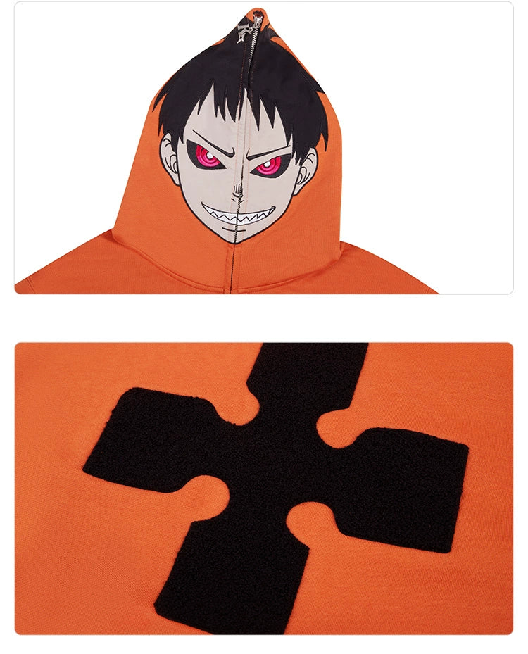 A close-up of the Seakoff "Fire Force Inspired Orange Zip-Up Hoodie" showcases its striking streetwear fashion, boasting anime elements with a cartoonish face, red eyes, and a menacing smile on the hood. A black cross-shaped design completes this 400GSM oversized style.