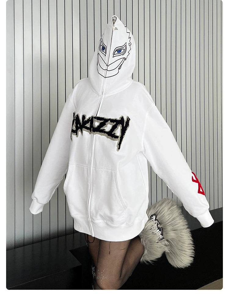 Wearing a Berserk Griffith-Inspired Hoodie, an oversized 400GSM white zip-up anime sweatshirt with "ARIEZZY" across the front and red sleeve design while standing against a striped wall, this person showcases furry-accented footwear—a perfect style for Berserk fans.