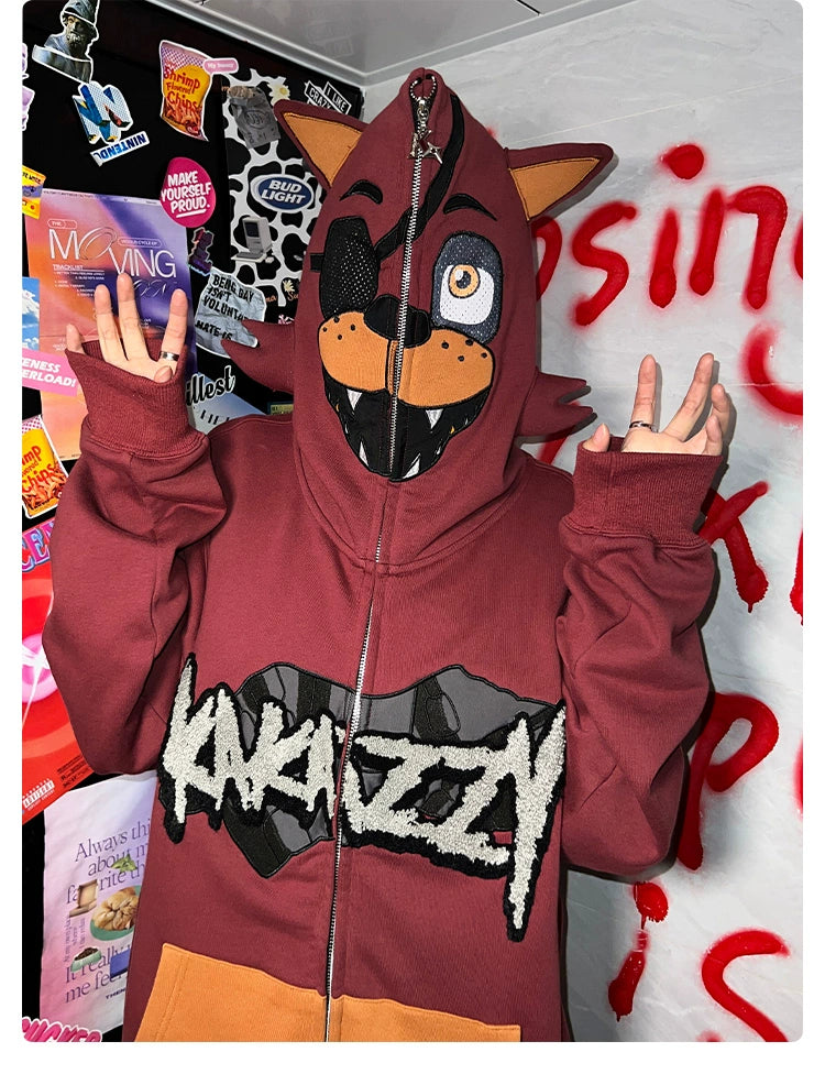 A person is wearing a Seakoff’s Foxy-Inspired Hoodie, an oversized 400GSM red zip-up sweatshirt styled like a cartoon fox with an eye patch from Five Nights at Freddy&