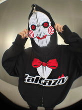 A person is wearing a Seakoff Saw-Inspired 400GSM Oversized Black Zip-Up Hoodie. Featuring Billy the Puppet&