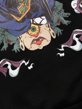 This abstract design on a black background showcases an upside-down creature with one eye and an open mouth, encircled by green hands and white flowing forms, capturing the dynamic artistry of the Jujutsu Kaisen Geto Suguru Anime Hoodie.