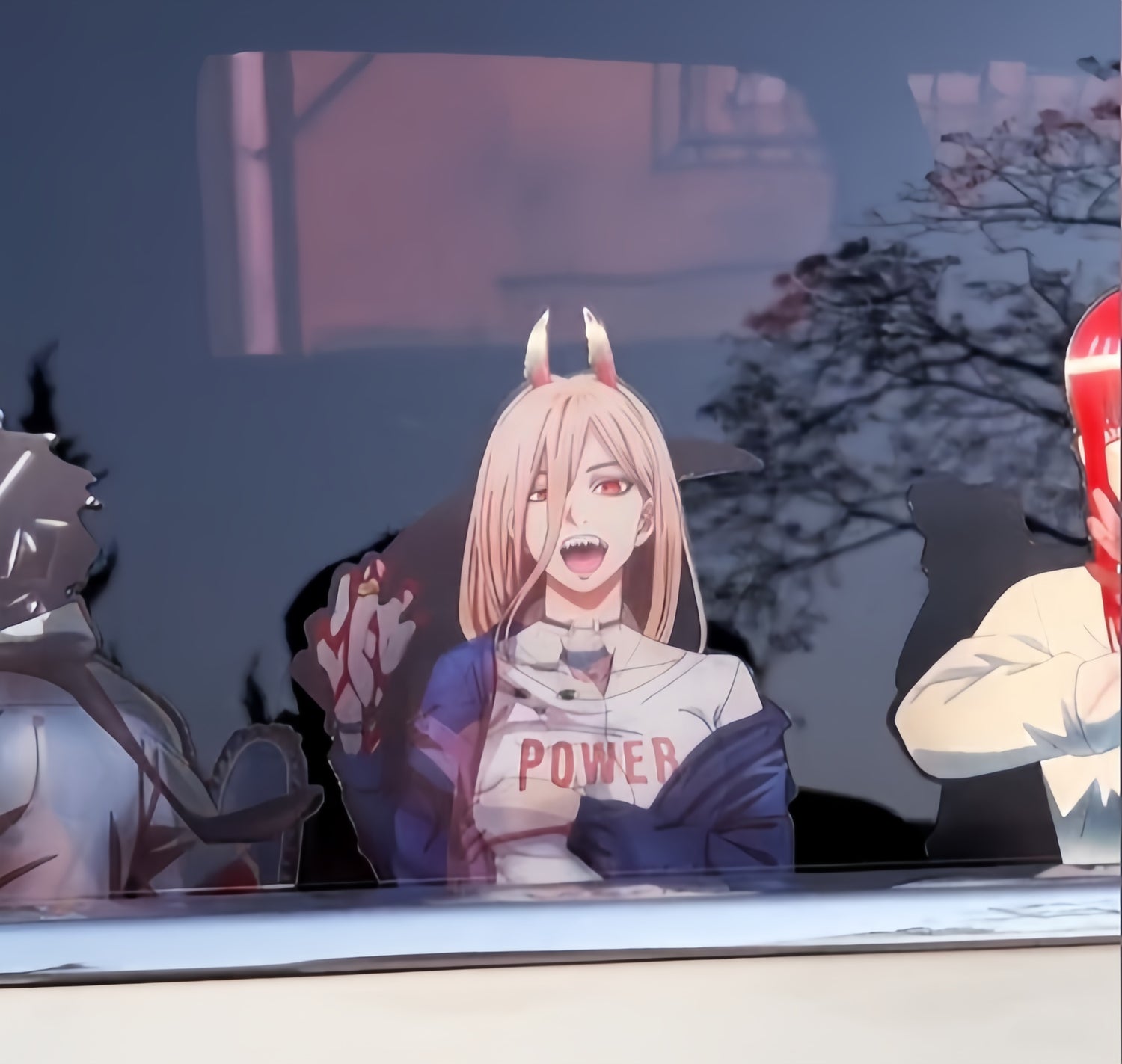 A car window is decorated with stickers featuring anime characters. The central character has light pink hair, horns, and a jacket that reads "Power," holding a gesture with one hand. Other characters are partially visible on either side.