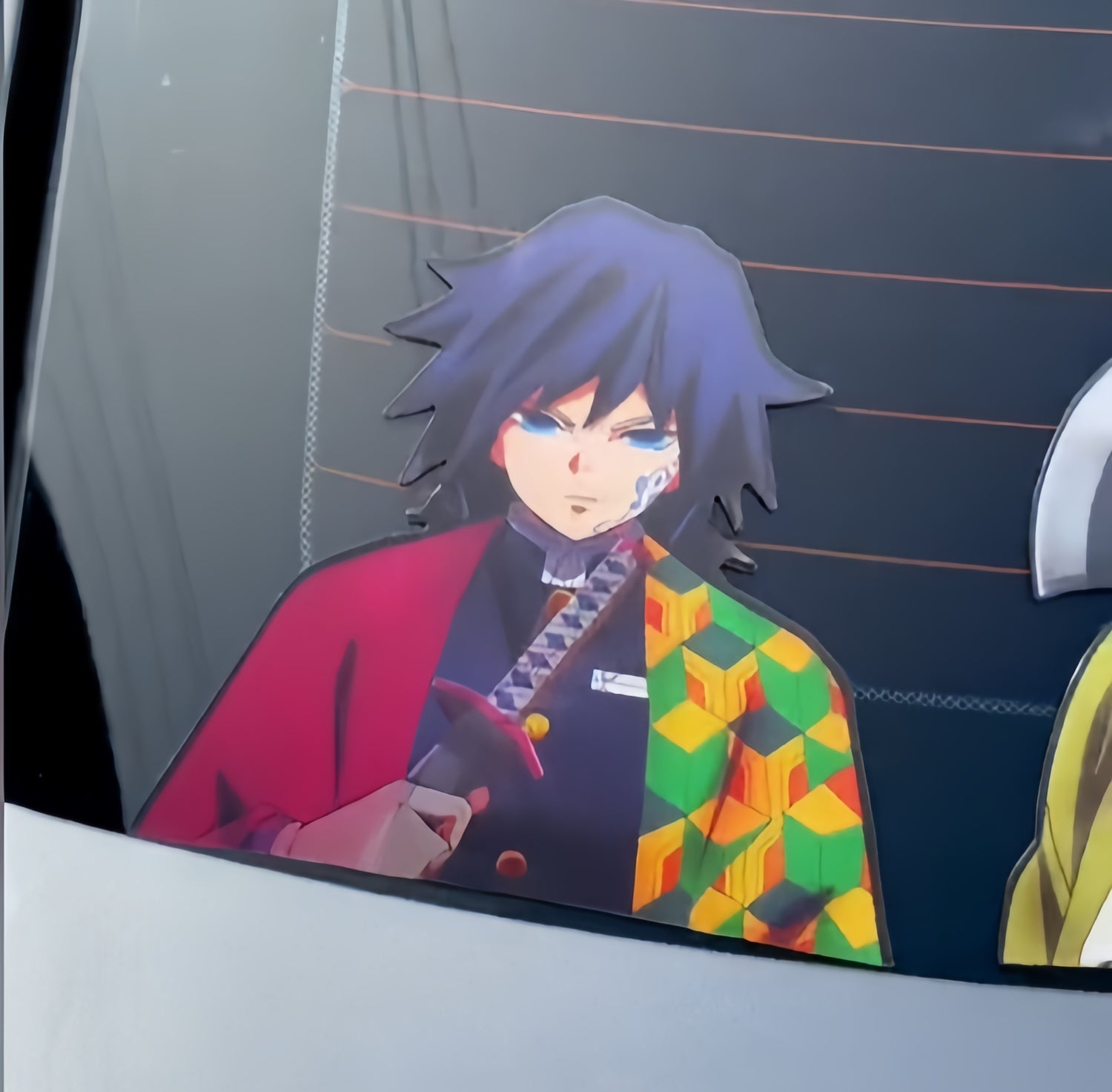 An anime character with blue hair and a distinctive haori featuring green, yellow, orange, and red patterns is seen through a car window. The character has a serious expression and holds a sword with a red sheath.