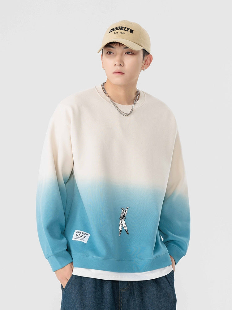A person wearing a SEAKOFF Limited Edition Dragon Ball Sweatshirt with a cream-to-blue Goku Spirit Bomb gradient design, a "Brooklyn" cap, denim pants, and a chain necklace stands against a light gray background.