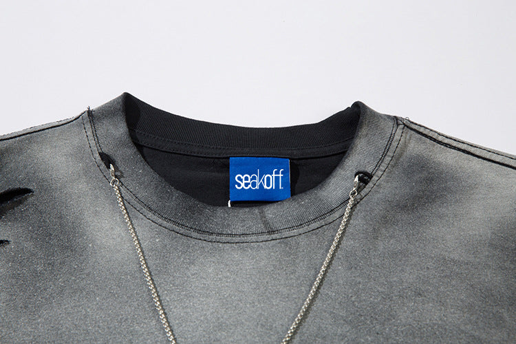 A close-up showcases the Limited Edition Death Note Long Sleeve Shirt, featuring a gray distressed design and black collar, with anime streetwear flair. A blue "seal off" tag graces the neck, enhancing its allure. Two thin silver chains drape elegantly over this unique piece by Death Note.