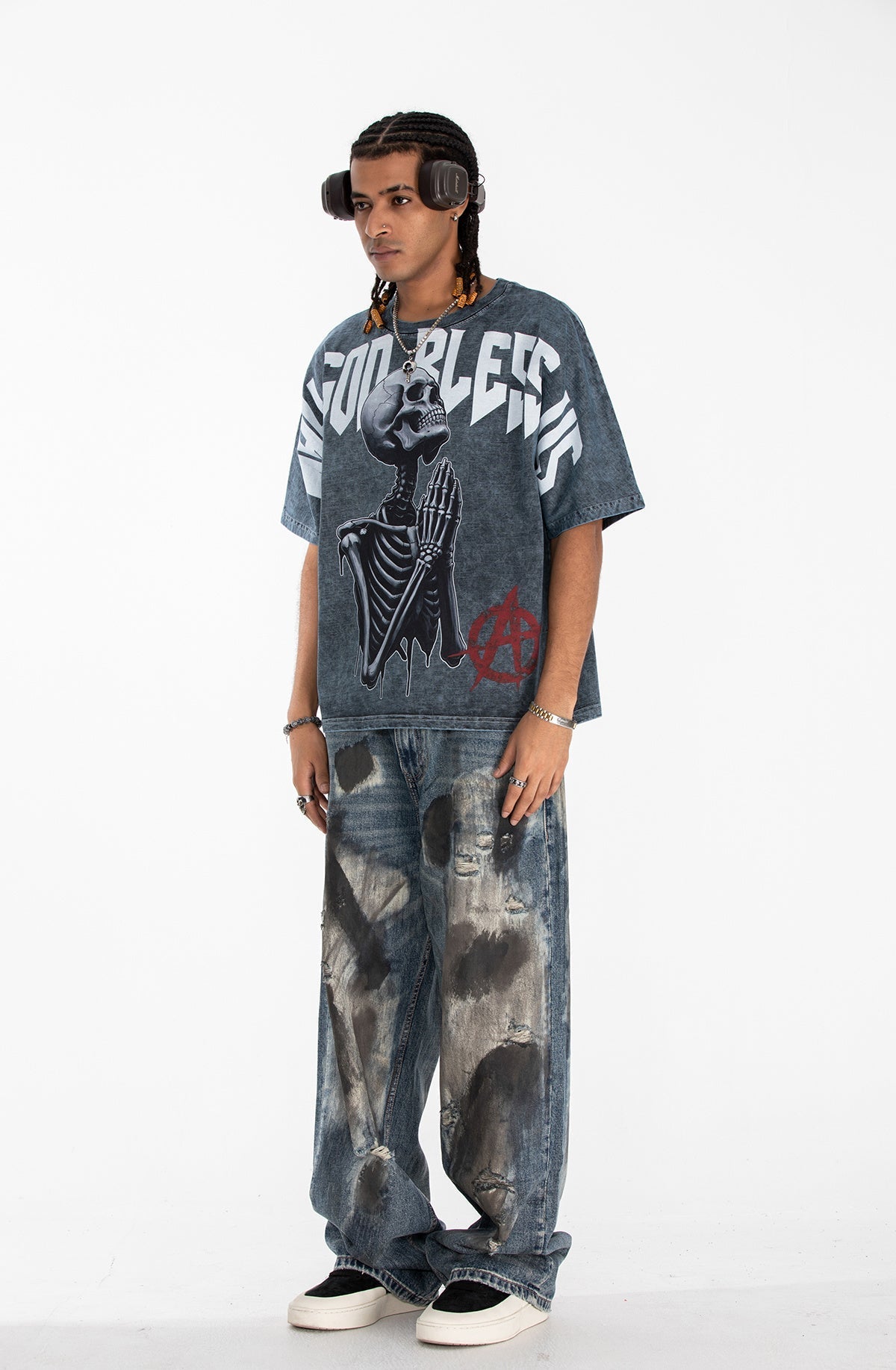 Oversized gothic graphic tee with praying skeleton print, worn with baggy distressed jeans on a male model