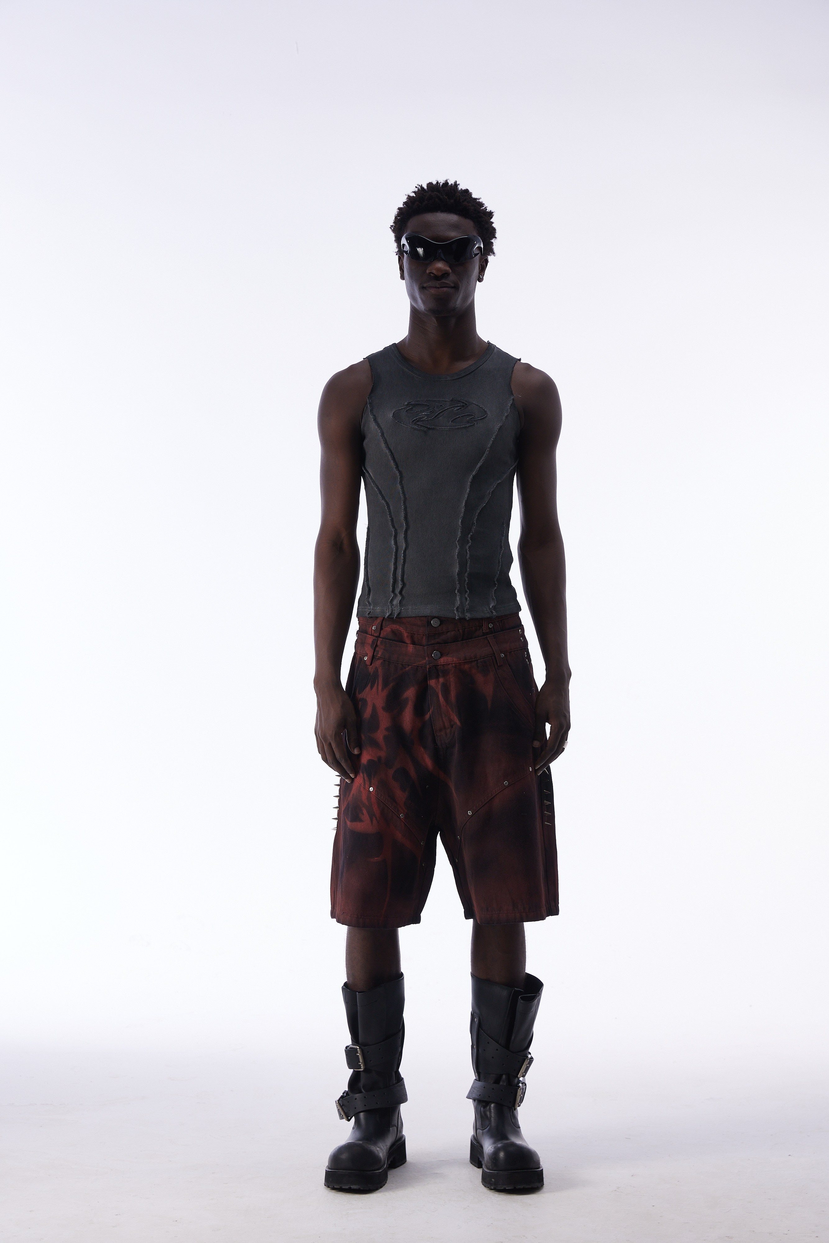 Front view of model wearing burgundy tribal jorts and gray ribbed tank top
