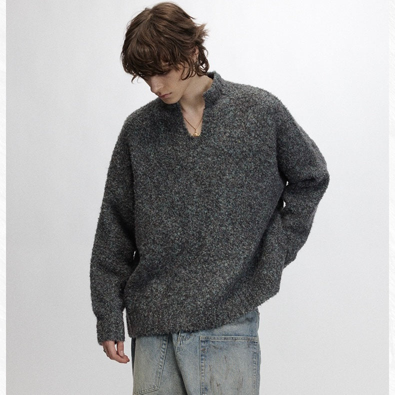 Model wearing loose dark boucle half-zip sweater with relaxed fit and long sleeves