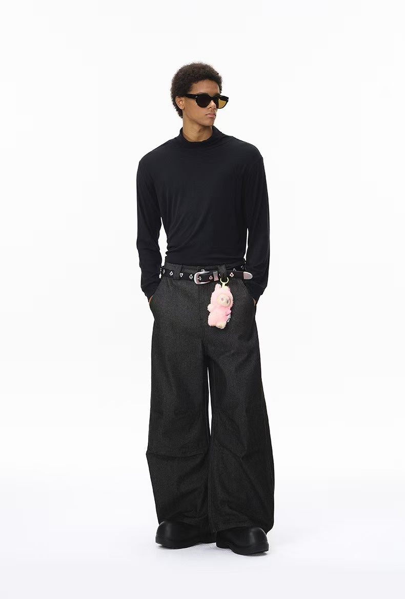 Model wearing black wide-leg pants with a belt and chain accessory, full-body front view