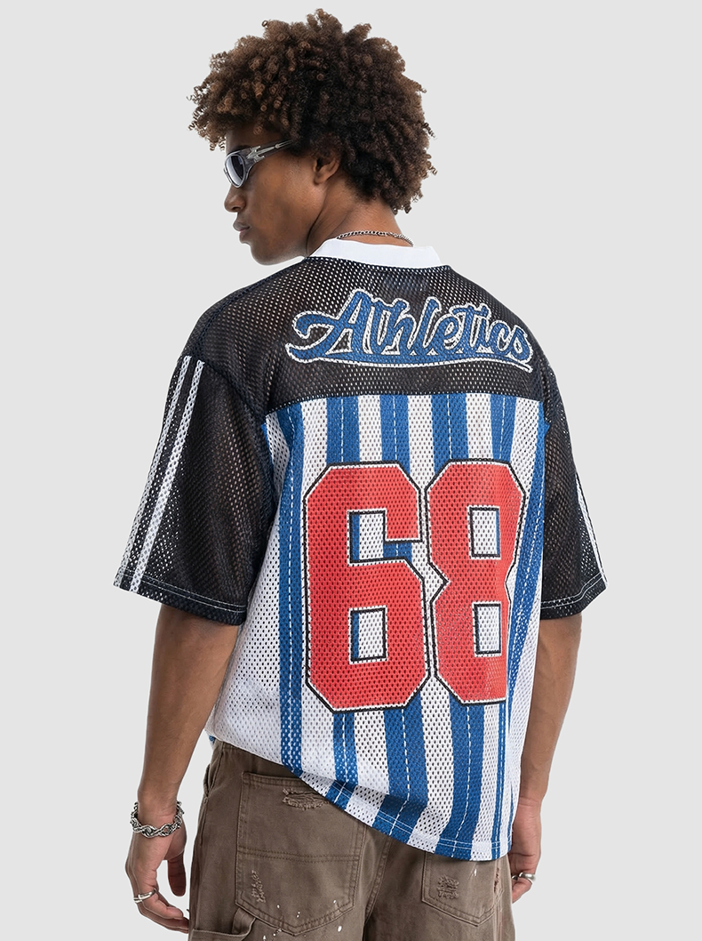 Back view of man wearing a black and blue mesh varsity jersey with Athlethics 68 graphic and striped details