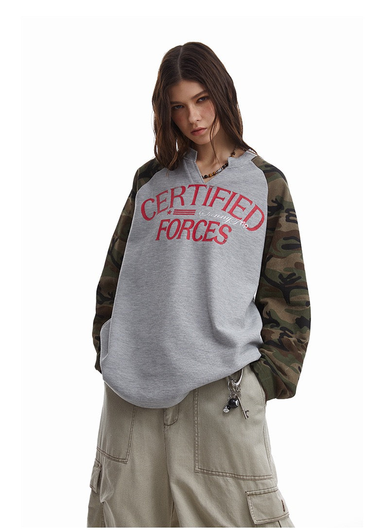 Model wearing gray raglan thermal tee with camouflage sleeves and red Certified Forces graphic, front view
