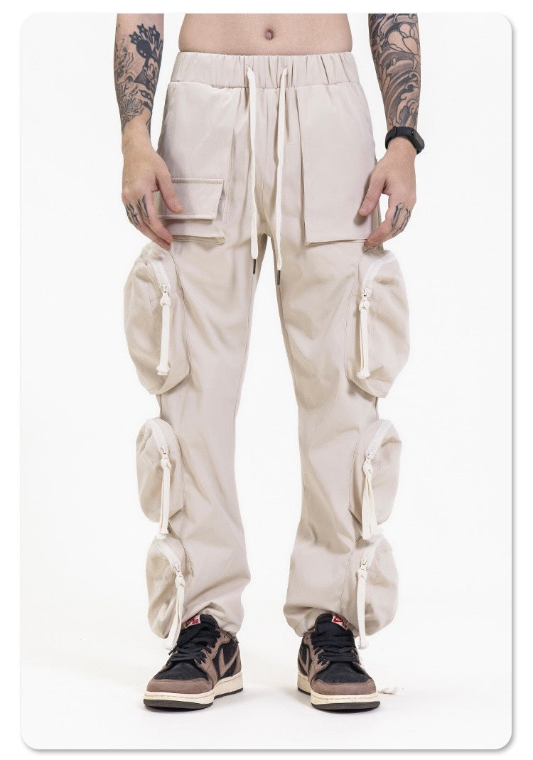 Cream utility cargo pants worn on model, front view with large flap pockets and side pouches