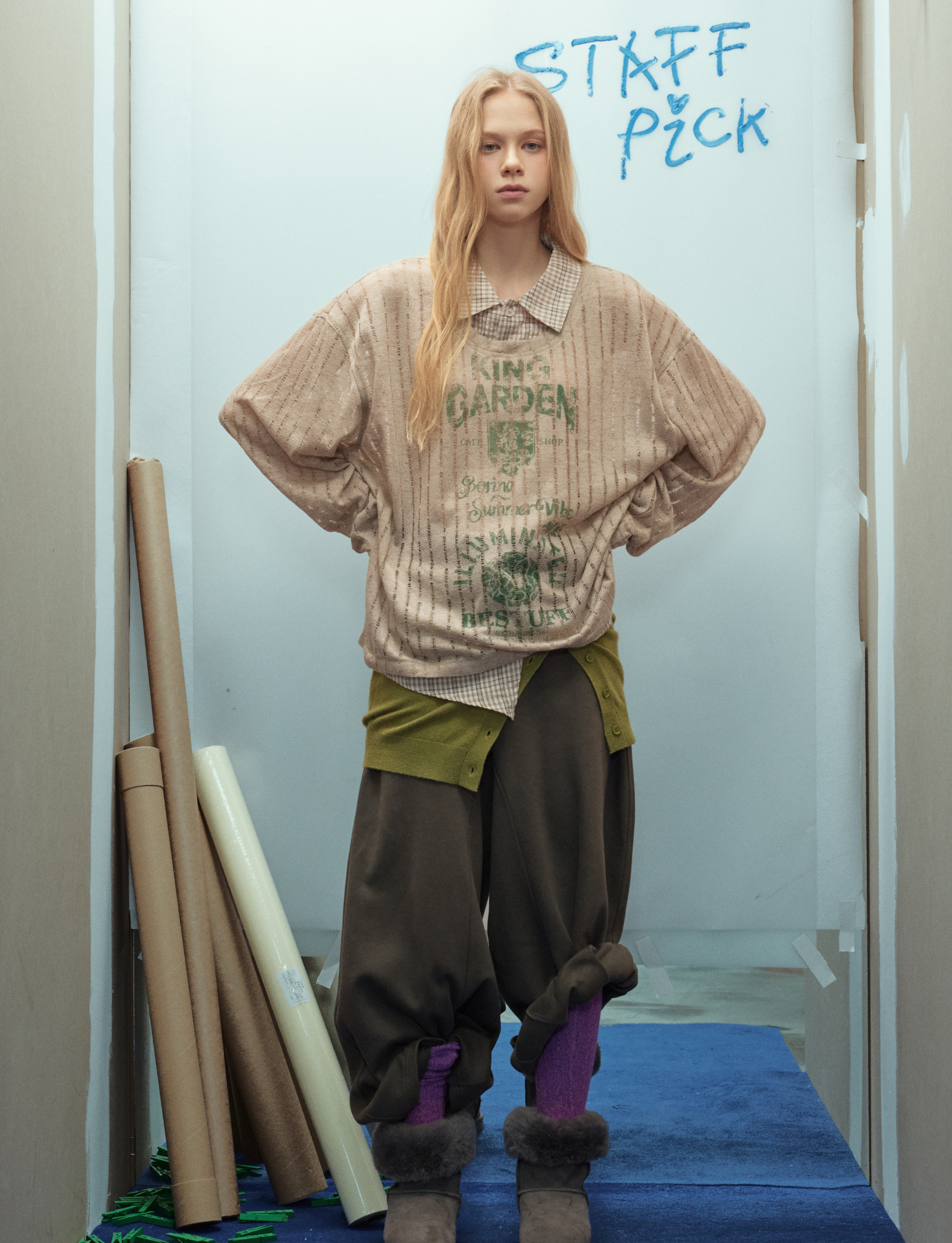 Beige graphic mesh top worn over layers, front model view
