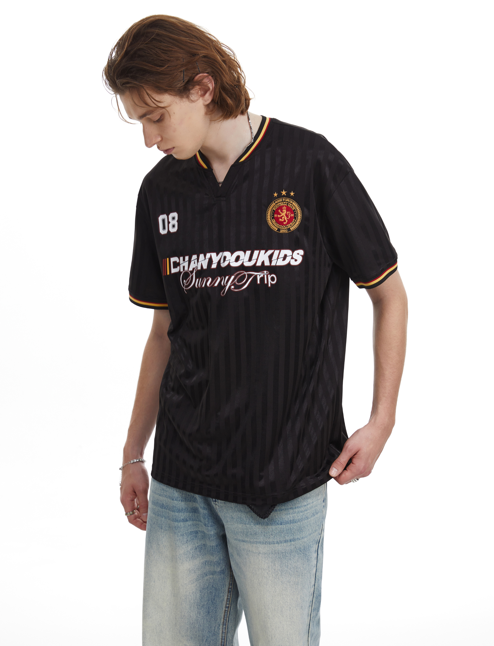 Black mesh soccer jersey tee with varsity-style trim and Sunny Trip graphic on a model wearing light-wash jeans