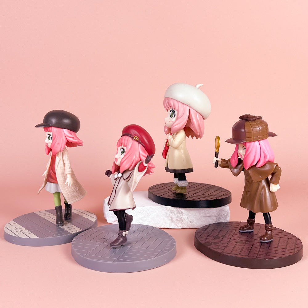 Four pink-haired figurines wearing different outfits and hats stand on round bases. The background is a soft pink. Each figure holds a distinct pose, with one holding a magnifying glass.