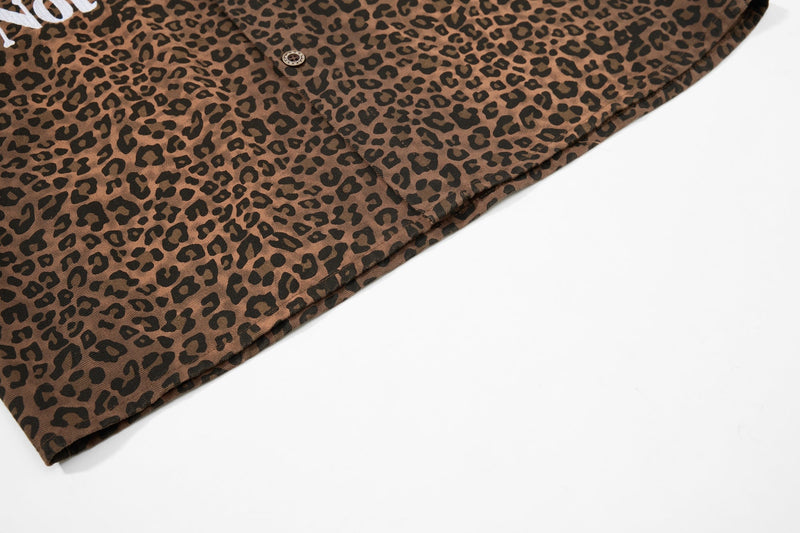Leopard print button-up shirt in brown and black with a bold allover animal pattern on a white background