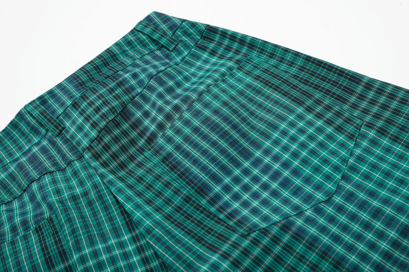 Close-up of green plaid shorts back pocket and waistband stitching