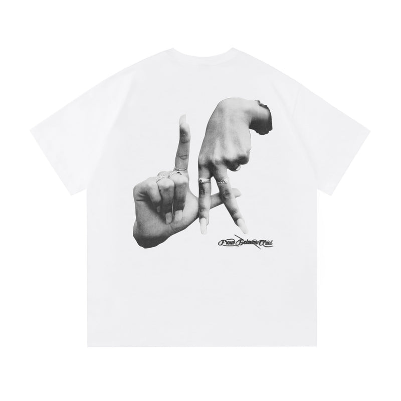 White oversized tee with black hand gesture graphic and Saludo Estevan Oriol logo on chest