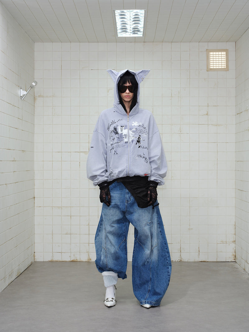 Front view of model wearing gray graphic zip hoodie with hood up