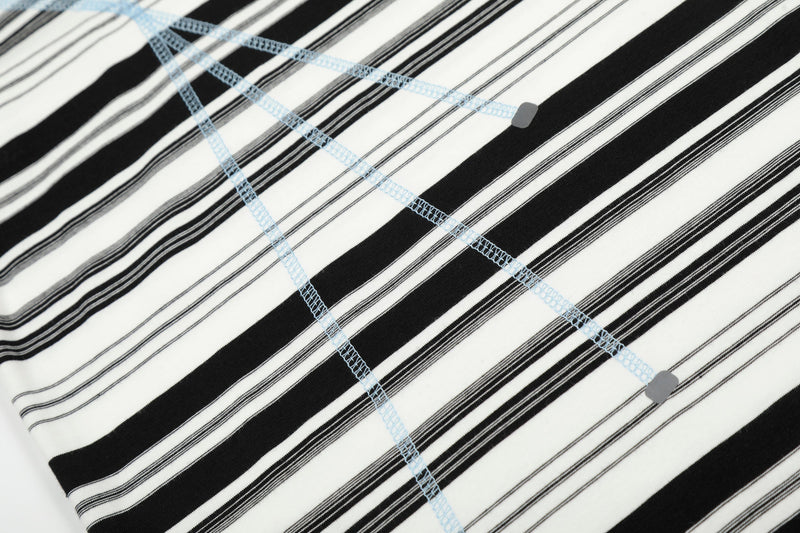 Close-up of black and white striped shirt with light blue seam stitching across the front