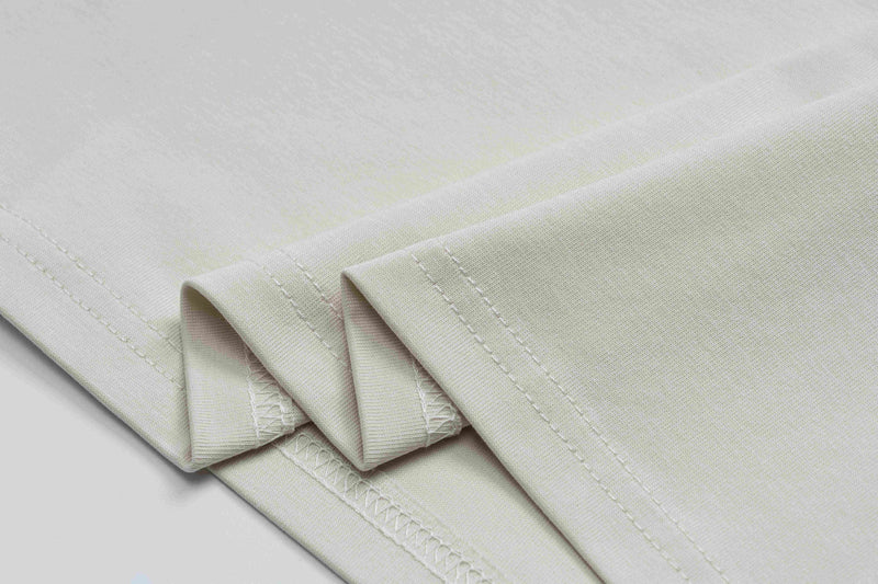 Folded cream vintage punk graphic tee with visible stitched hems on a clean white background