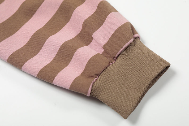 Close-up of ribbed cuff on pink and brown striped hoodie sleeve