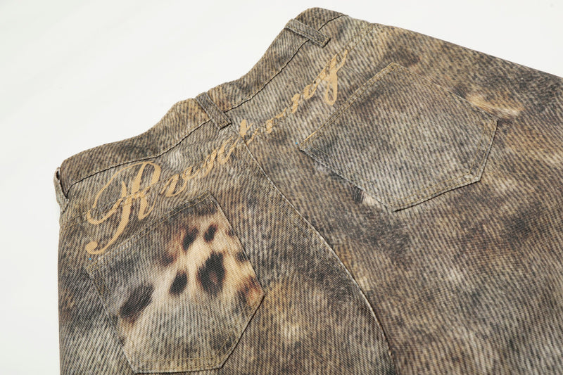 Back waist close-up showing script print and patch pocket on washed denim