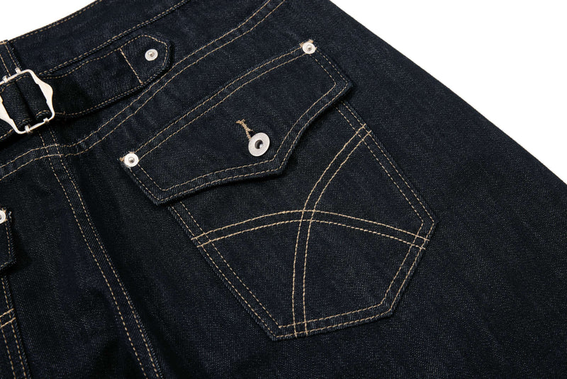 Close-up of the back pocket on dark wash denim pants with contrast stitching and flap detail