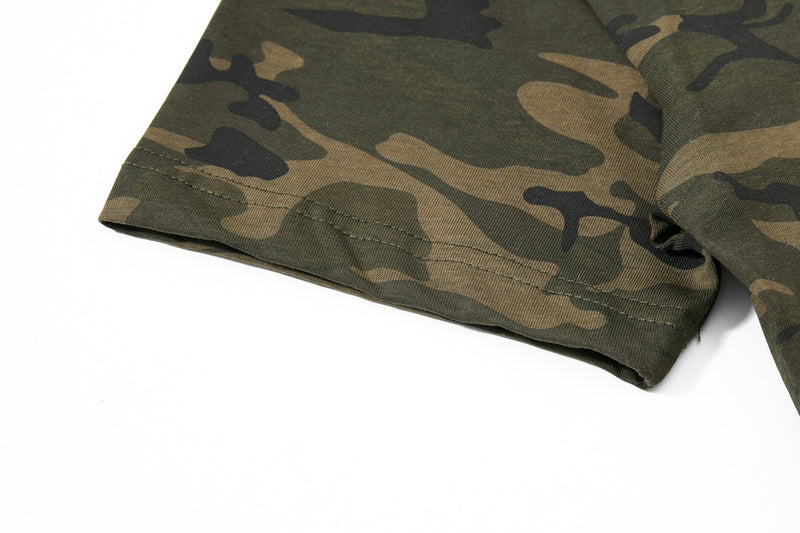 Close-up of an olive and tan camouflage graphic T-shirt hem with stitched detailing on a white background