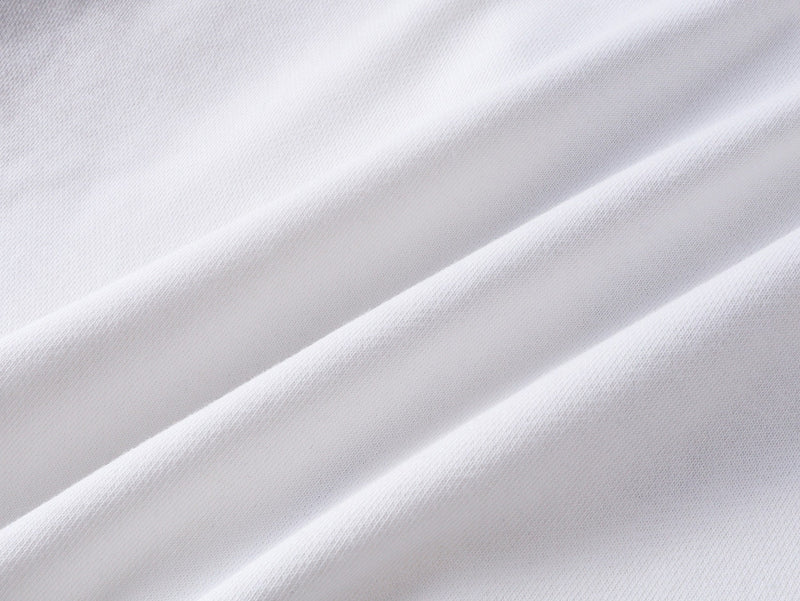Close-up of plain white sweatshirt fabric with soft diagonal folds and knit texture