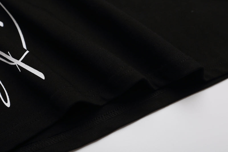 Close-up of a black graphic polo shirt with white print and neatly stitched hem on a clean white background