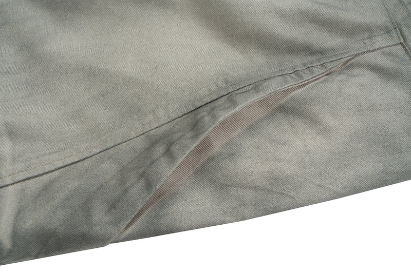 Close-up of side seam and panel detail on grey cotton pants