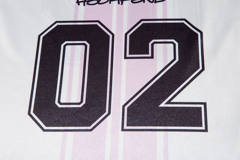 Close-up of white jersey front with large 02 number and pink stripe pattern