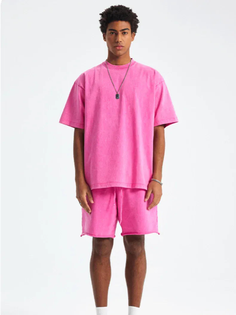 A man faces forward in a Custom Anime Character Pink Washed T-Shirt - Personalized Anime Style Tee, paired with matching shorts, white socks, and a necklace, set against a plain white background.
