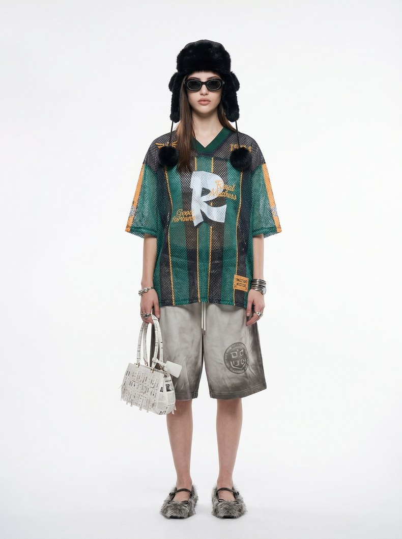 Green and black mesh jersey T-shirt with orange stripes, oversized fit, and streetwear graphic details, worn with shorts