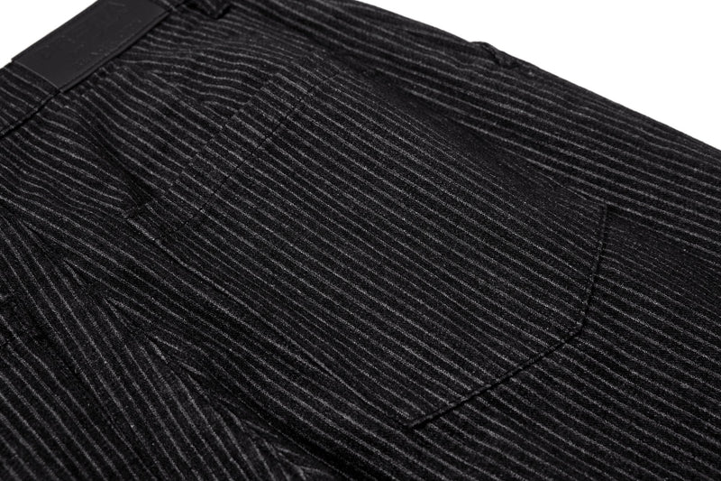 Close-up of black pinstripe trousers showing back seam and panel details