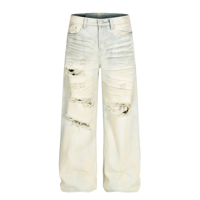 Cream wide-leg distressed jeans with heavy ripped knees, front view