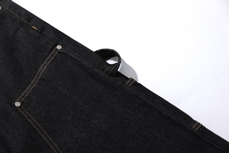 Close-up of black denim side panel with visible cargo strap and seam stitching
