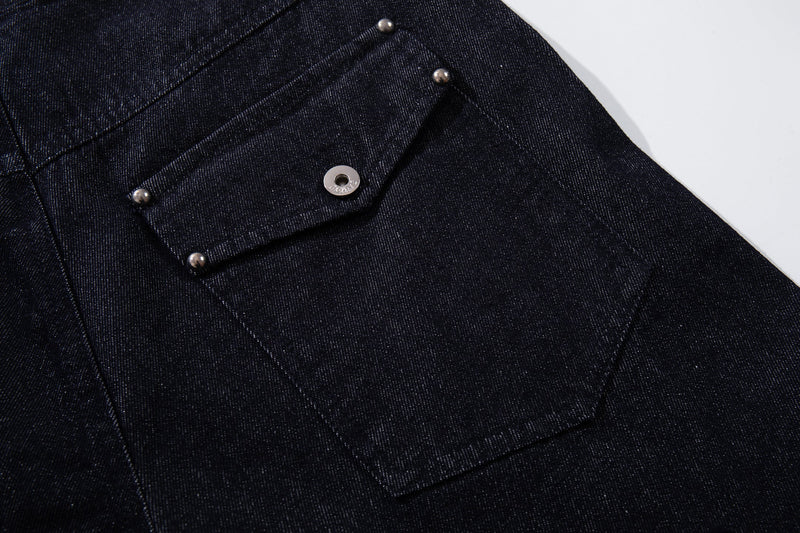 Close-up of the side flap pocket and snap detail on dark indigo denim pants