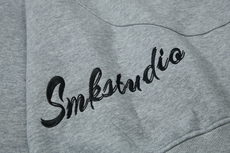Close-up of black script graphic on the gray hoodie chest