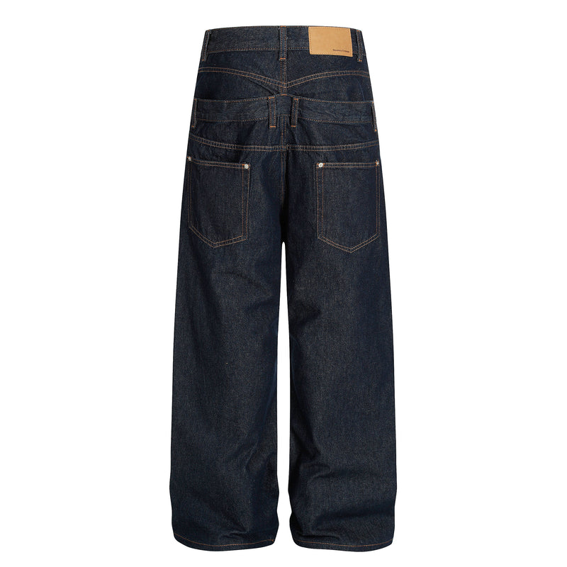 Back view of deep indigo wide-leg jeans with tan patch, contrast stitching, and square back pockets