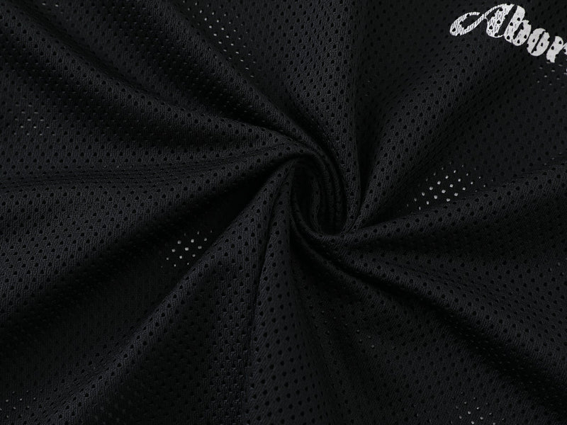 Close-up of black mesh shirt fabric gathered in a swirl, showing open-hole texture