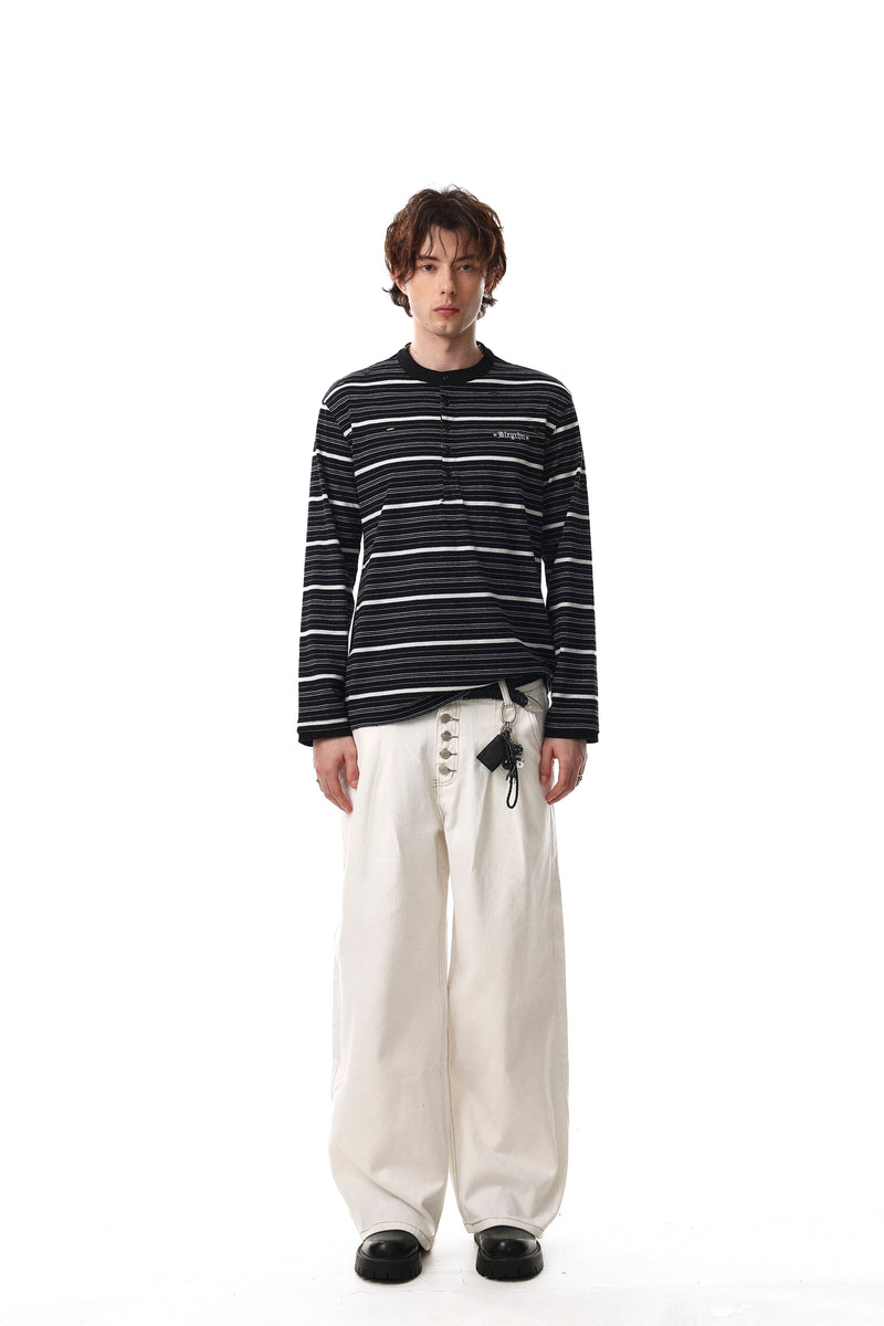 Full-length model view in black striped long sleeve Henley tee with loose fit and black pants