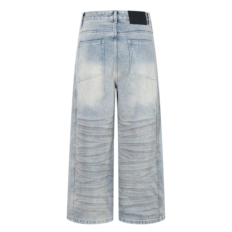 Back view of light wash wide-leg jeans with patch pockets and faded distressed finish